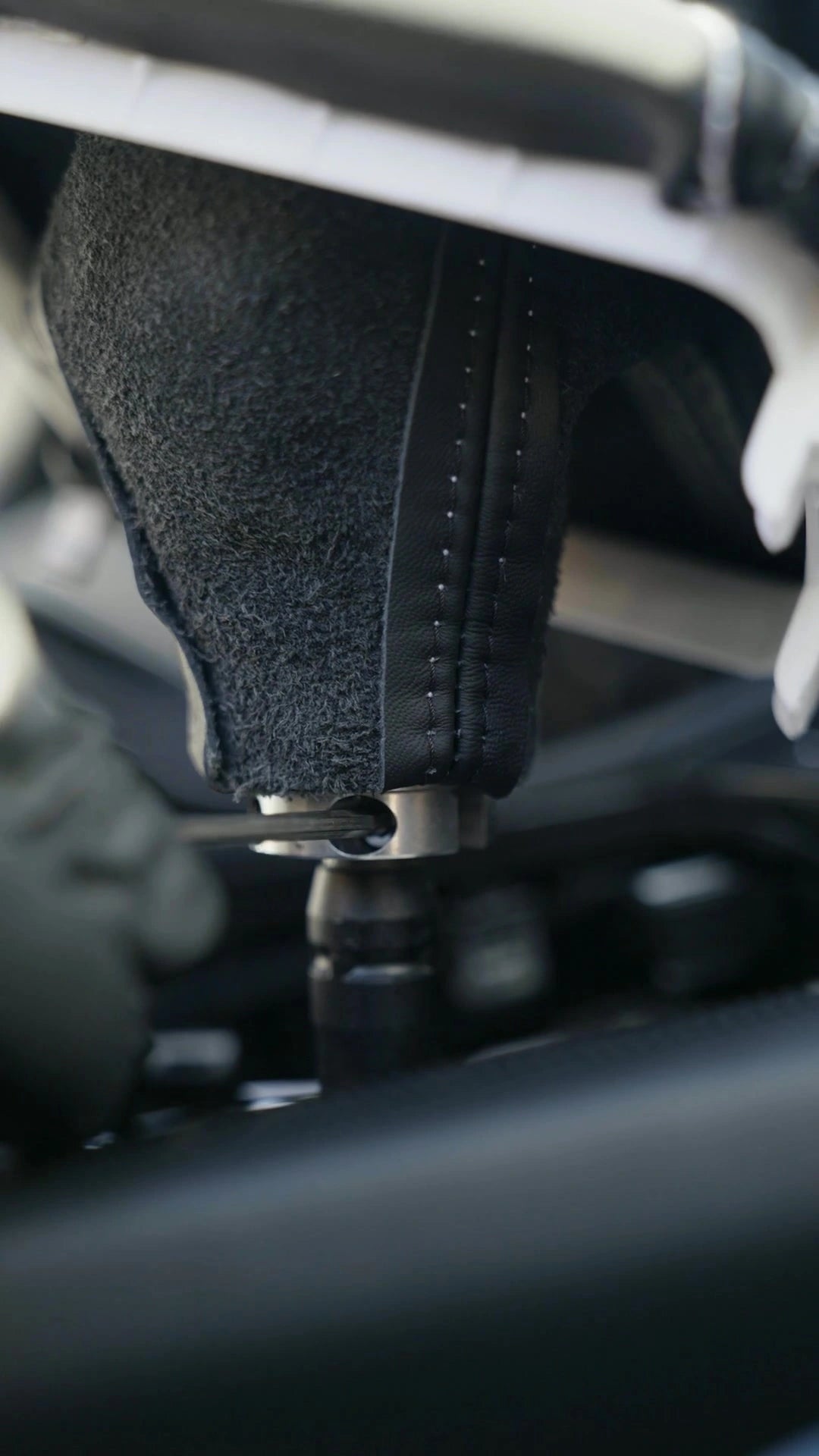 Actual installation video frame: a gloved hand tightening the Euro Impulse shifter with an Allen key